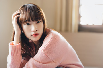 Portrait young asian teenager woman wear pink sweater.