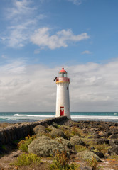 Fototapeta na wymiar Port Fairy Lighthouse, built in 1859 is a magnificent red and white sentinel that stands on the easternmost tip of Griffiths Island