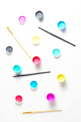 pattern of acrylic paint in cans and brushes. view from above, vertical frame, simple flat lay composition