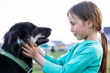 The girl gently looks in the big dog eyes