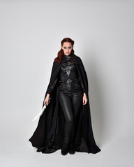 fantasy portrait of a woman with red hair wearing dark leather assassin costume with long black...