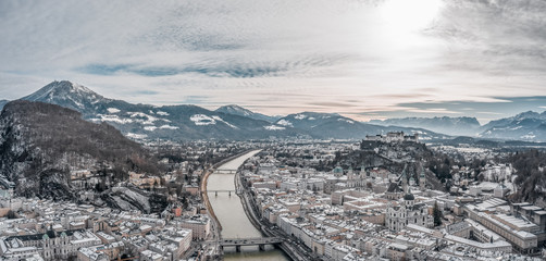 Obraz premium Aerial drone shot view of snowy Salzburg city old town by river in the morning with Salzburg Cathedral Hohensalzburg