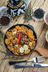 pilaf with lamb meat, dried fruits, dates and walnuts, on a wooden table