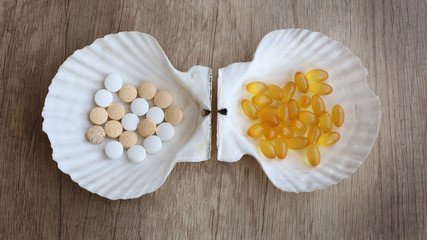 Tablets of calcium and shell on a wooden table. Medical concept. Minerals for health. Top view. omega 3