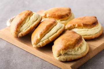 Wood board with hot homemade buns stuffed with cottage cheese. Selective focus.