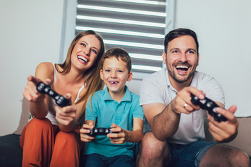 Obraz premium Happy family playing video games at home and having fun together.