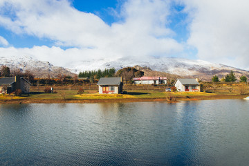 Fototapeta na wymiar Getaway Lodge by a dam and Snowy Mountains