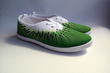 white sneakers decorated as a kiwi side view on a gray background