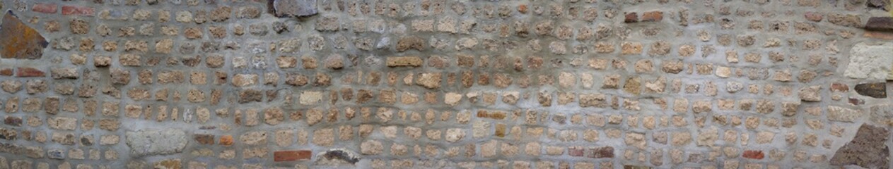Very old middle-aged wall. Stone wall made of bricks and various stones.