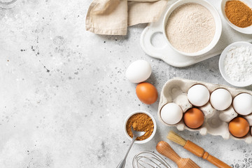 Ingredients for baking on a culinary background. Eggs, flour, cinnamon, sugar, soda on the kitchen table. Concept of preparation for baking. Top view with space for text