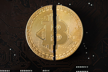 Cryptocurrency bitcoin with cutting traces in the middle on computer mainboard. bitcoin halving concept