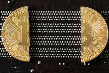 Cryptocurrency bitcoin with cutting traces in the middle on computer mainboard. bitcoin halving concept