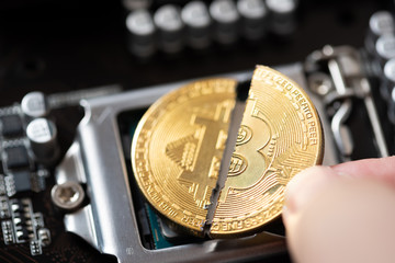 man hand pick up Cryptocurrency bitcoin with cutting traces in the middle on computer mainboard....