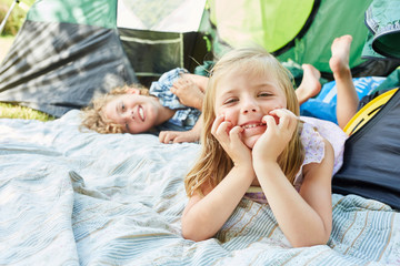  Kinder faulenzen zusammen beim Camping - obrazy, fototapety, plakaty