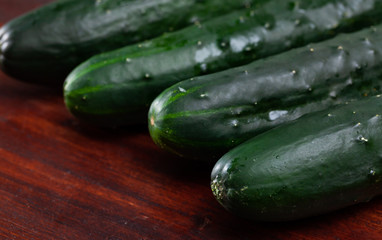 Fresh cucumbers on wooden table in home kitchen