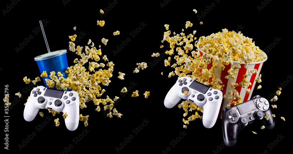 Wall mural flying popcorn, cup of soft drink and video game joystick isolated on black