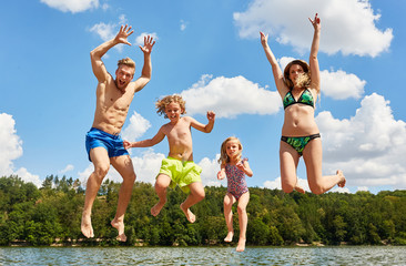 Familie im Urlaub springt in die Luft