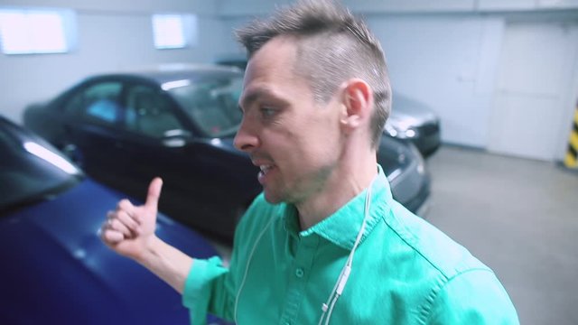 A video blogger gives an overview on the topic of cars in a garage. A form of transmitting information through video, the exchange of information.