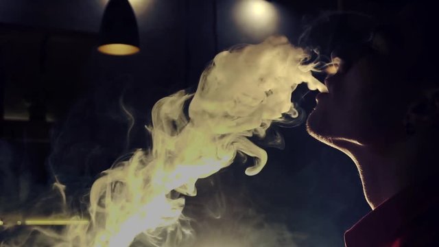Young man smoking hookah in a bar