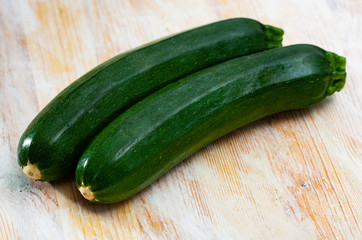 Raw green zucchini on wooden surface in  kitchen