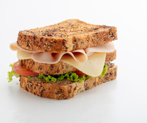 sandwich Integral con pavo y queso sobre fondo blanco. Integral sandwich with turkey and cheese on white background.