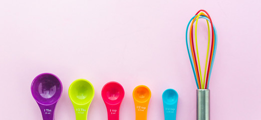 The colorful whisk beside with set of measuring spoon in pastel color tone concept