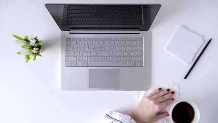 Time lapse. Working office day. Woman worker cleaning laptop using antivirus wet wipe. type keyboard sitting in an office table with cup of coffee and working with graphics and charts - Powered by Adobe