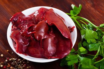 Image of raw rabbit liver with garlic and greens