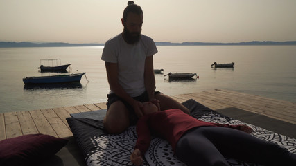 Masseur working with sen lines in traditional thai yoga massage for young girl. © Alexander Belinskiy