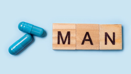 Banner. Two blue capsules and the inscription man. Pills for men's health and sexual energy on an isolated background. Concept of erection, potency. Treatment of male infertility and impotence