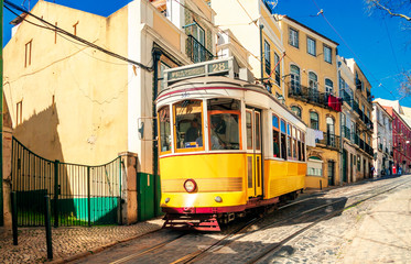 Naklejka na ściany i meble Vintage yellow tram on the old streets of Lisbon, Portugal. Portugal tram. Famous landmarks of Lisbon.