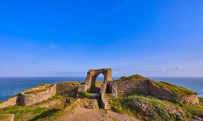 Image of Grosnez Castle keep constructed circa 1330 and located in the North West corner of Jersey early morning with the sea in the background and blue skys.  Jersey, Channel Islands, UK