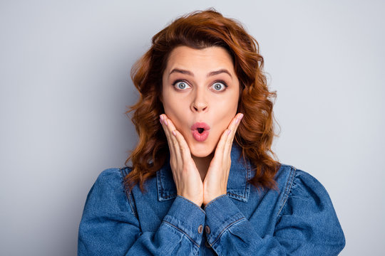Closeup photo of pretty curly foxy lady arms on cheeks cheerful good mood open mouth listen amazing news wear casual blue jeans denim shirt isolated grey color background