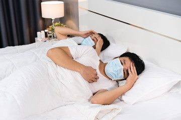 Obraz na płótnie Canvas sick couple in medical mask headache and suffering from virus disease and fever in bed, coronavirus (covid-19) pandemic concept.