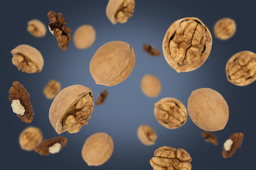 Falling walnuts isolated on a dark background with clipping path as package design element and advertising. Top view.