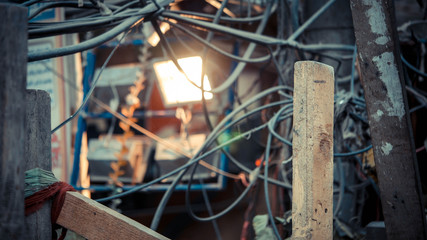 Black wire tangled with light luminating in background