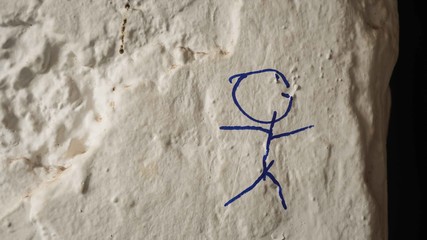 Blue stick figure drawn on bumpy wall