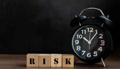 RISK on wood block with clock, conceptual