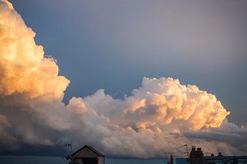 Cloudscape photography, fluffy clouds coloured with sunset light in London