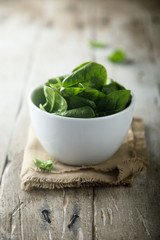 Fresh baby spinach in a white bowl