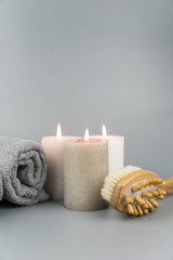 Obraz na płótnie Canvas Towel with aromatic candles and massage brush. Aromatherapy and beauty. Concept set of harmony, balance and meditation, spa, relax, beauty spa treatment.