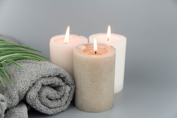 Fototapeta na wymiar Towel with aromatic candles. Aromatherapy and beauty. Concept set of harmony, massage, balance and meditation, spa, relax, beauty spa treatment.