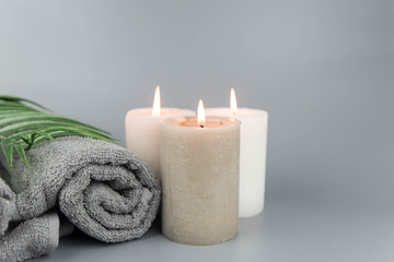 Obraz na płótnie Canvas Towel with aromatic candles. Aromatherapy and beauty. Concept set of harmony, massage, balance and meditation, spa, relax, beauty spa treatment.