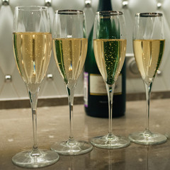 champagne in glasses. Sparkling wine in glasses with long legs. Glasses with champagne stand in the kitchen