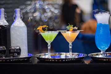Cocktail party in a night club. Fun, entertainment, celebration. Nightlife youth. Alcoholic drinks. Barman made stylish modern neon cocktails.