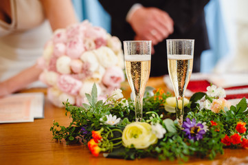 Two glasses of champagne on the background of the bride that makes the signature