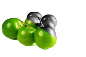 Close-up macro fresh green sour plum. Greengage on white background.  Colorful, black and white.  Creative concept.