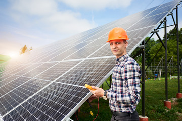 Male engineer with a sensor in his hands, looking to the camera near the solar panels which reflect the rays of the sun under the blue sky. Solar in flat style on green background. Power station