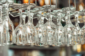 Lots of wine glasses hanging upside down