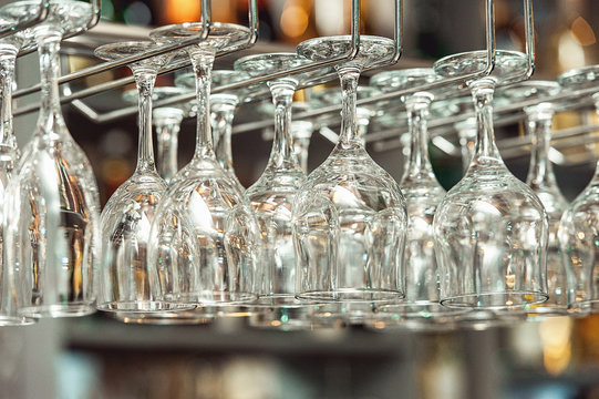 Lots of wine glasses hanging upside down - Powered by Adobe